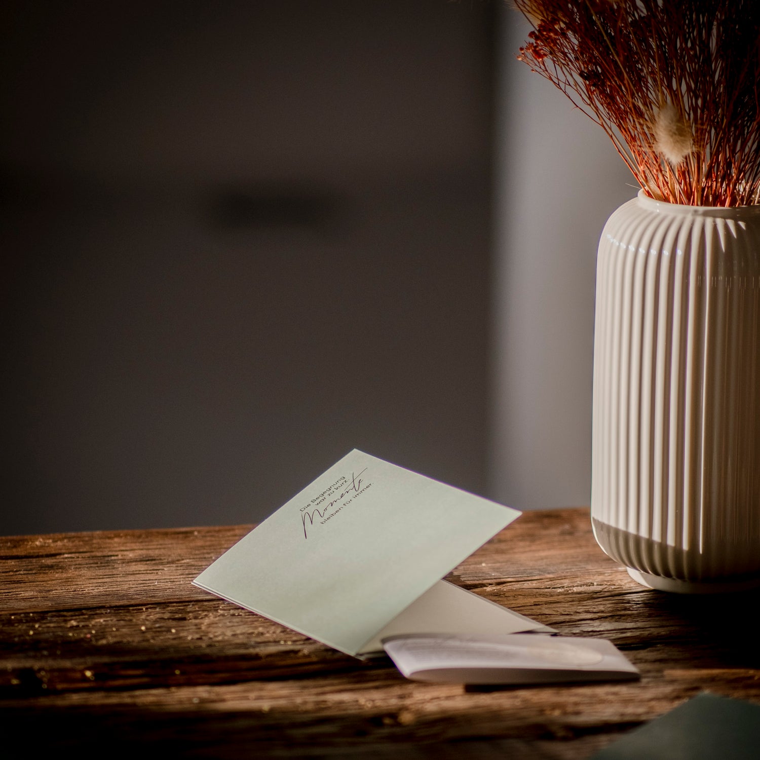 Trauerkarte Produktbeispiel der Stille Reise GmbH auf einem Eichentisch mit Vase und Trockenblumen